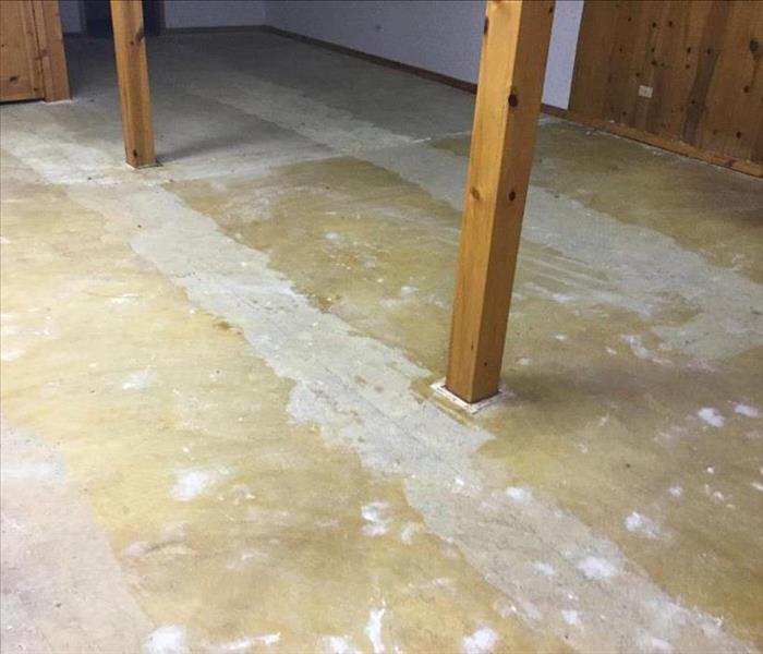 Dry concrete floor with wood support beams in a basement.