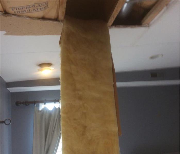 Insulation hanging down from a ceiling.