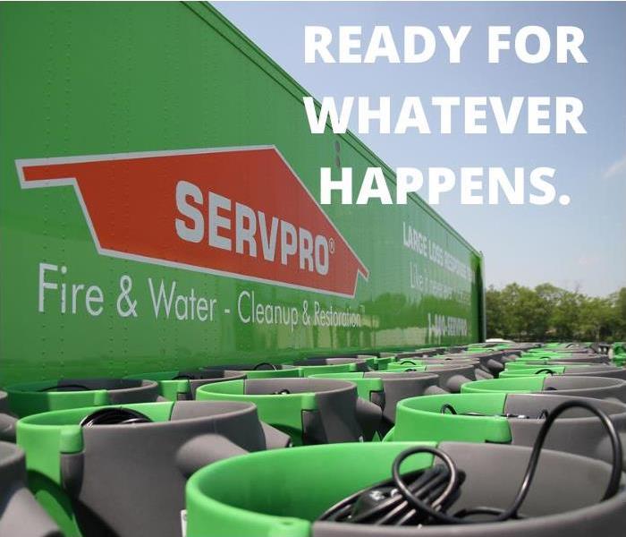 SERVPRO semi truck with several green air movers in front.